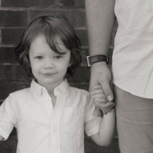 Boy with cleft lip holding hands with parent