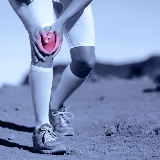 athlete holding knee representing knee pain